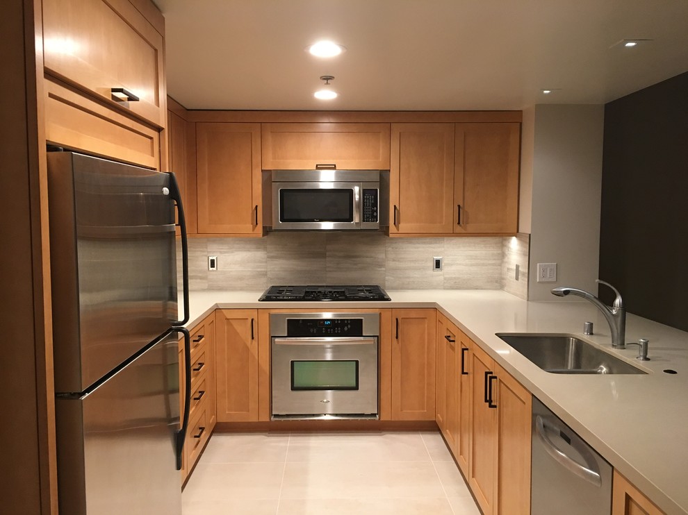 Example of a small transitional u-shaped ceramic tile and beige floor eat-in kitchen design in Los Angeles with an undermount sink, shaker cabinets, light wood cabinets, quartz countertops, gray backsplash, stone tile backsplash, stainless steel appliances and a peninsula
