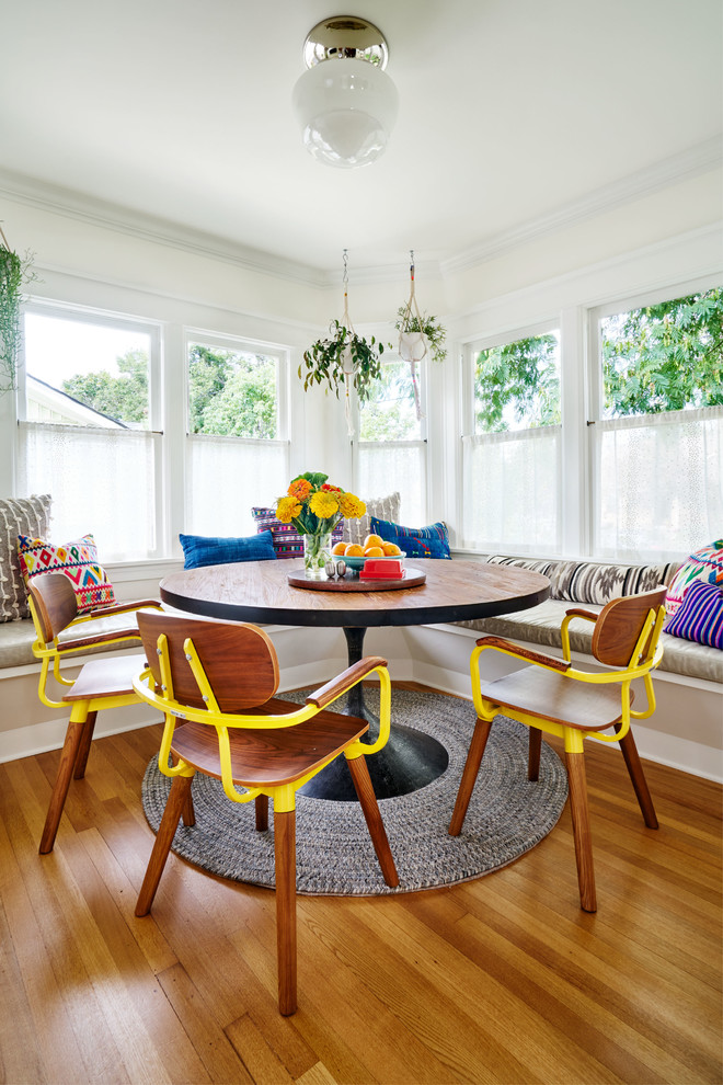 Photo of an eclectic separate dining room in Portland with white walls, medium hardwood floors and brown floor.