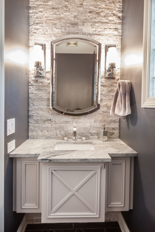 Photo of a small transitional powder room in Chicago with furniture-like cabinets, grey cabinets, beige tile, stone tile, blue walls and an undermount sink.