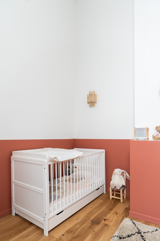 Foto di una grande cameretta per neonati neutra minimalista con pareti bianche e parquet chiaro