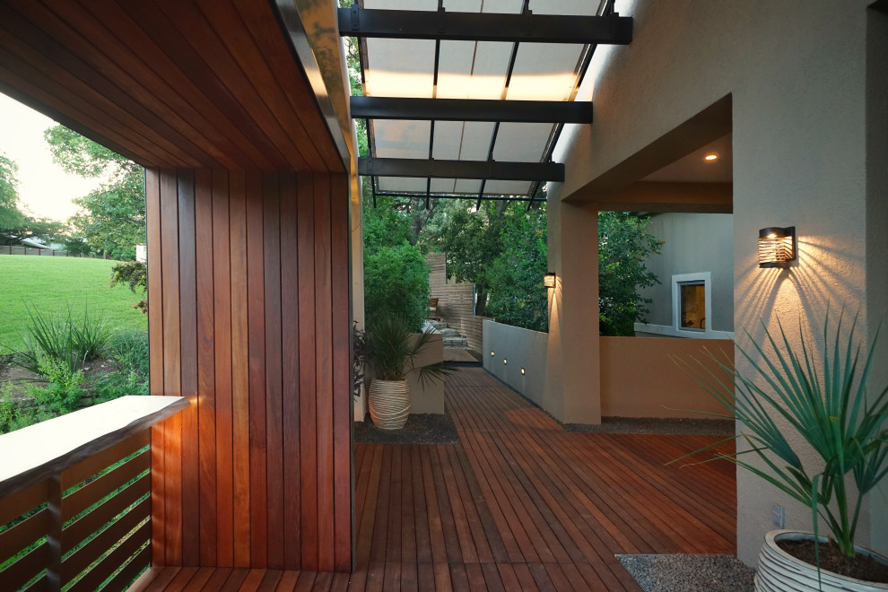 Idee per un piccolo patio o portico minimalista davanti casa con un giardino in vaso, pedane e un parasole