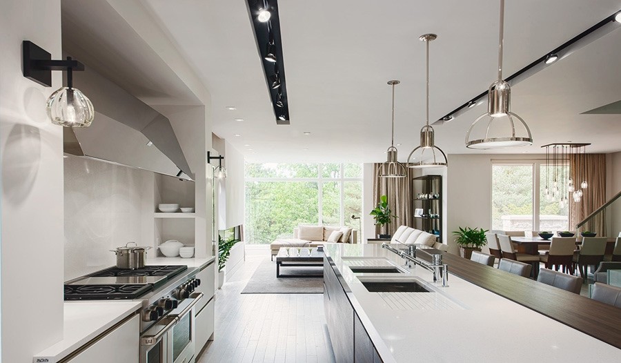 This is an example of a contemporary eat-in kitchen in Miami with an undermount sink, flat-panel cabinets, white cabinets, solid surface benchtops, white splashback, stone slab splashback, stainless steel appliances and light hardwood floors.