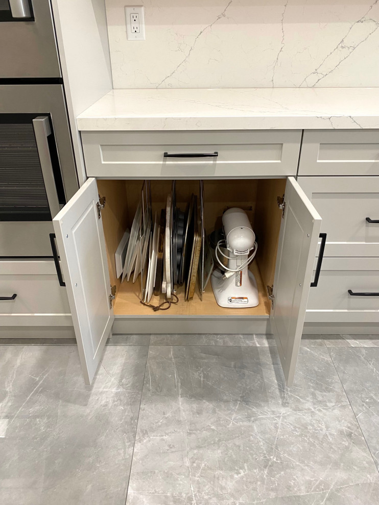 Inspiration for a mid-sized transitional l-shaped porcelain tile open concept kitchen remodel in Toronto with an undermount sink, shaker cabinets, gray cabinets, quartz countertops, white backsplash, quartz backsplash, stainless steel appliances, an island and white countertops