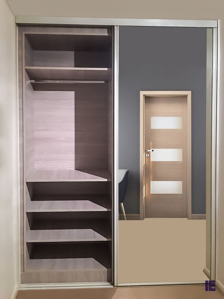 This is an example of a large modern standard wardrobe in London with glass-front cabinets, grey cabinets and feature lighting.