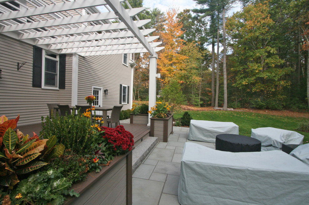 Photo of a transitional full sun stone landscaping with a pergola for fall.