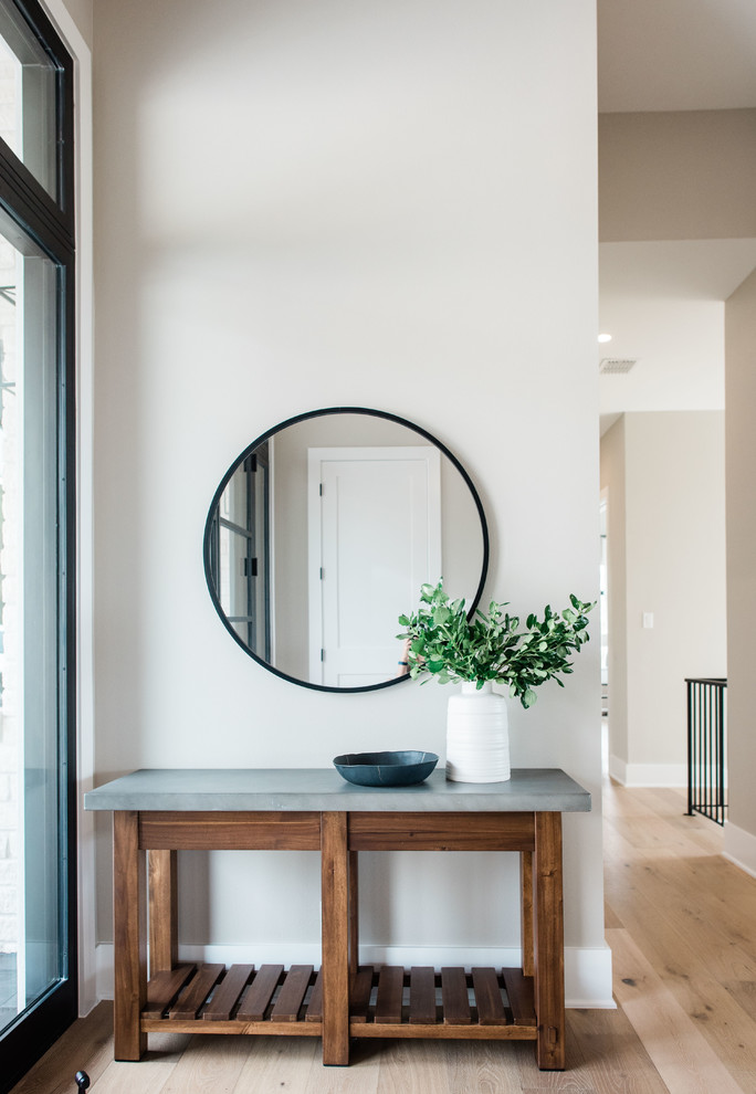 This is an example of a mid-sized transitional foyer in Austin with grey walls, light hardwood floors, a double front door, a black front door and brown floor.
