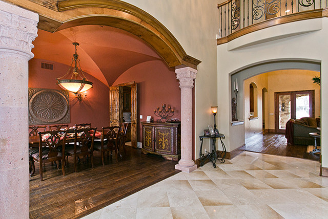 Example of a large classic travertine floor entryway design in Dallas with a brown front door