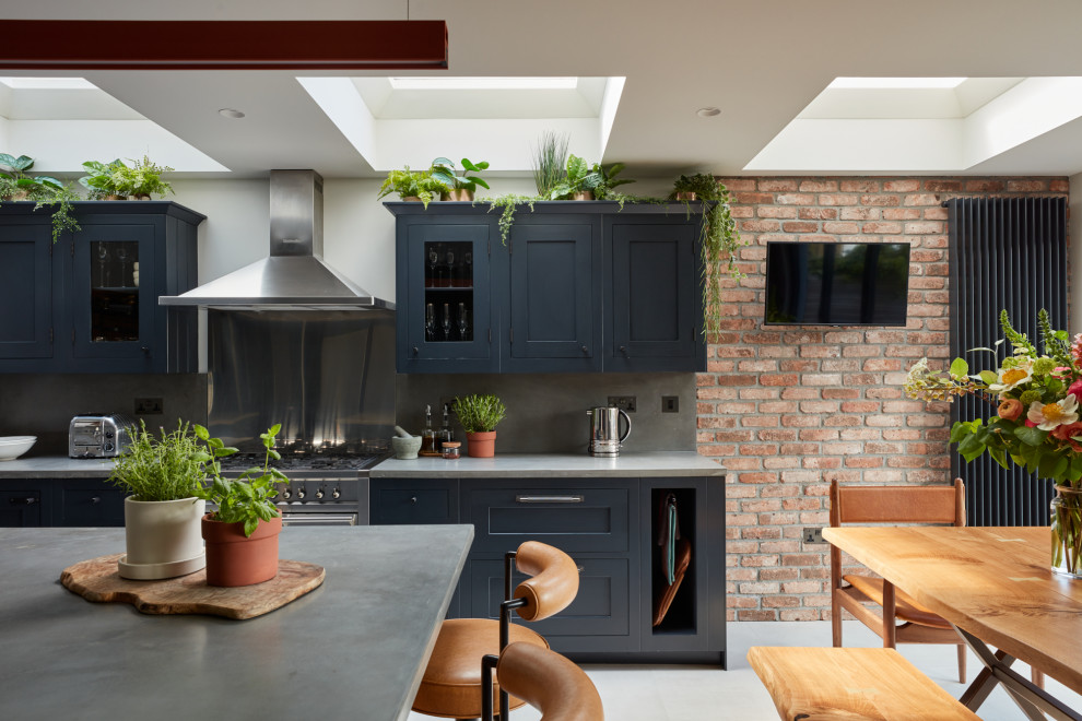 Design ideas for a medium sized eclectic l-shaped kitchen/diner in London with shaker cabinets, blue cabinets, concrete worktops, porcelain flooring, an island and grey worktops.