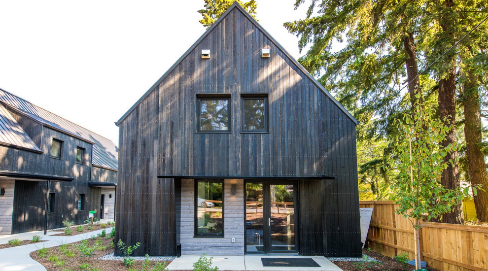 На фото: большой, деревянный, черный частный загородный дом в стиле модернизм с отделкой доской с нащельником с