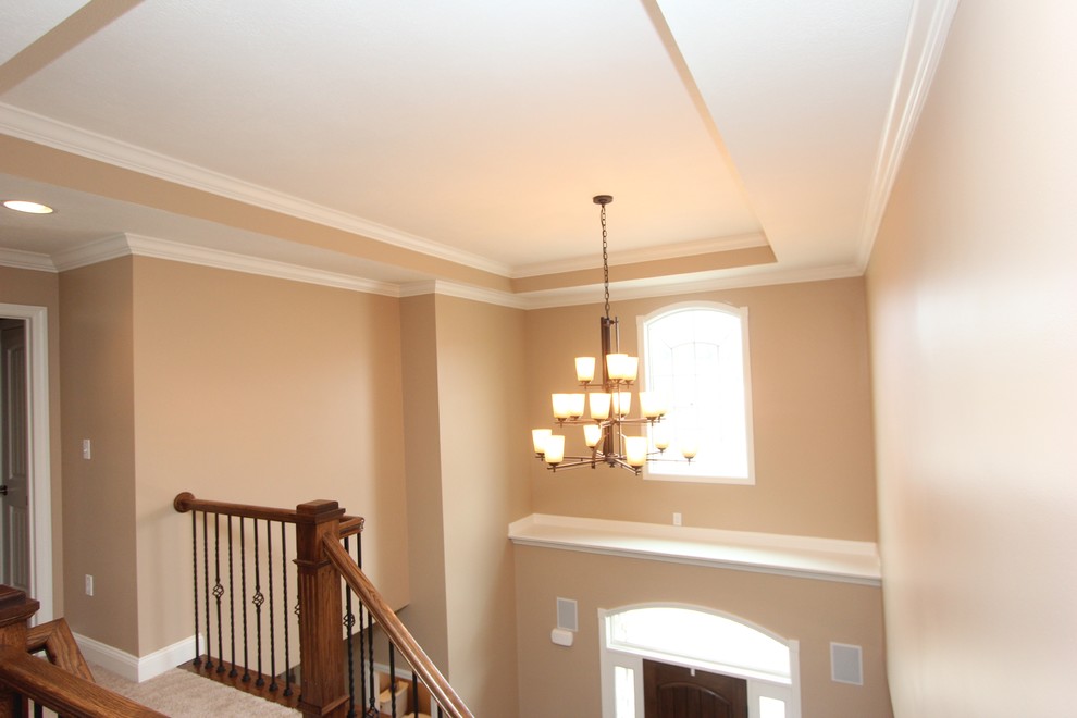 Example of a large transitional medium tone wood floor foyer design with beige walls and a dark wood front door