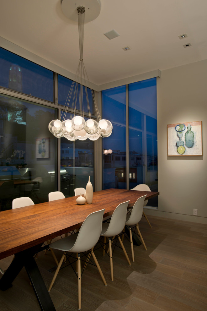 This is an example of a contemporary dining room in San Francisco with beige walls and medium hardwood floors.