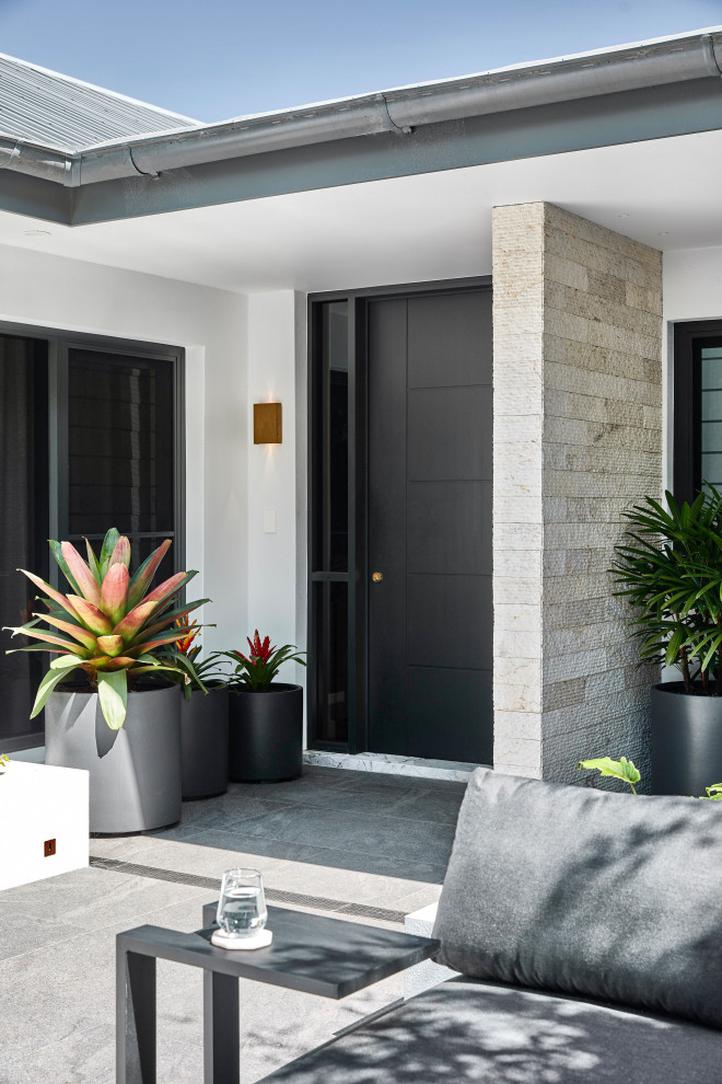 Photo of a medium sized contemporary front door in Sydney with white walls, ceramic flooring, a single front door, a black front door, grey floors and brick walls.