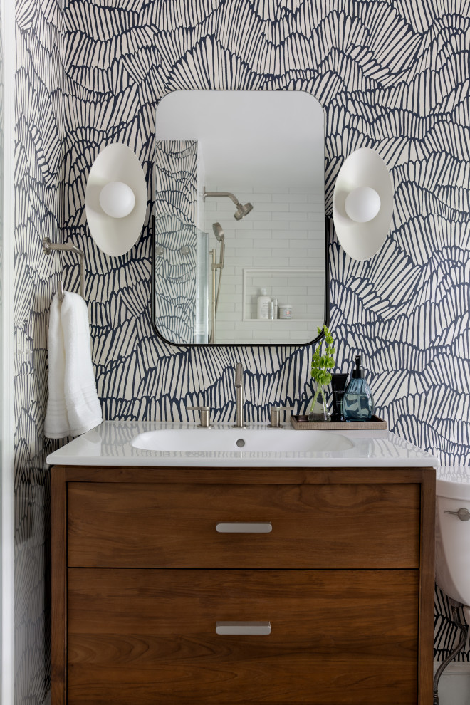 Bathroom - mid-century modern master white tile and ceramic tile mosaic tile floor, blue floor, single-sink and wallpaper bathroom idea in Boston with flat-panel cabinets, medium tone wood cabinets, a two-piece toilet, blue walls, an integrated sink, marble countertops, white countertops, a niche, a freestanding vanity and a hinged shower door