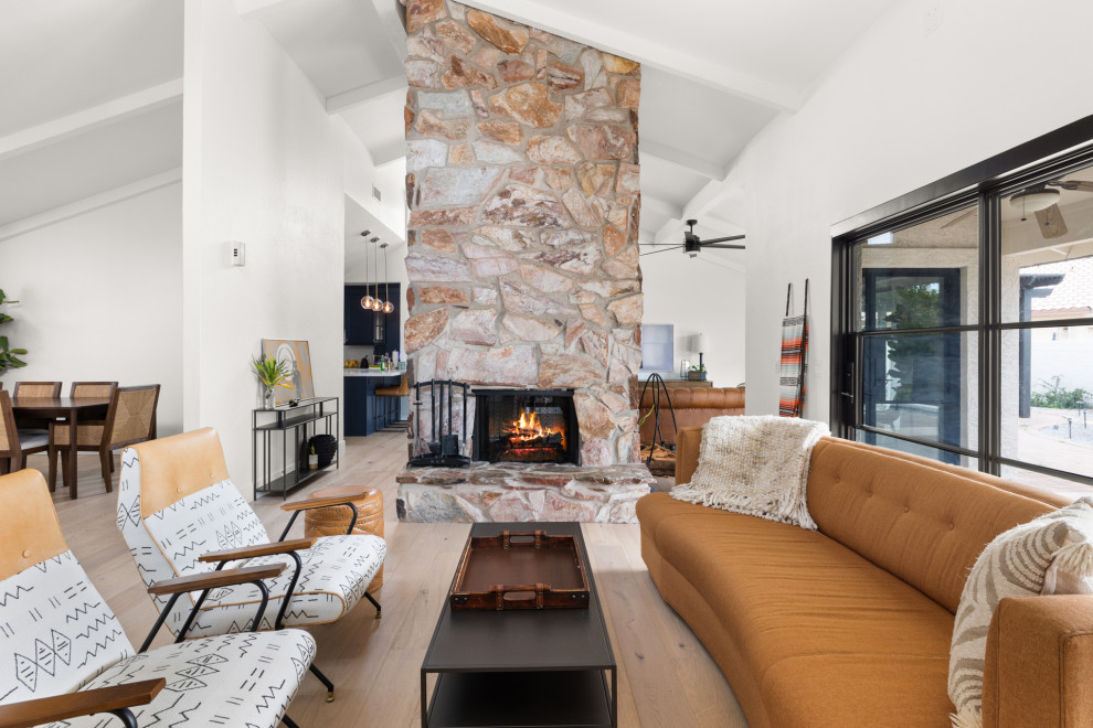 Inspiration for a large contemporary light wood floor and brown floor living room remodel in Phoenix with a two-sided fireplace