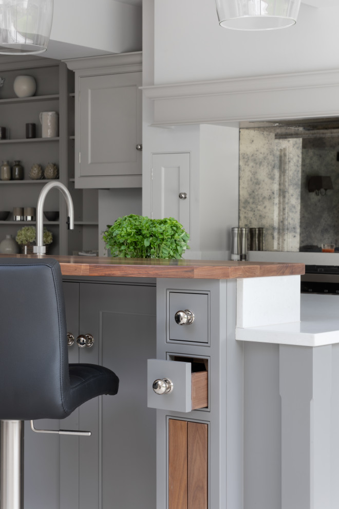 Design ideas for a large traditional l-shaped open plan kitchen in Surrey with a drop-in sink, shaker cabinets, grey cabinets, quartzite benchtops, metallic splashback, mirror splashback, stainless steel appliances, limestone floors, with island, grey floor, white benchtop and exposed beam.