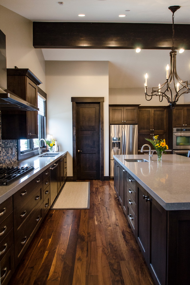 Photo of a large country l-shaped eat-in kitchen in Salt Lake City with an undermount sink, shaker cabinets, dark wood cabinets, quartzite benchtops, multi-coloured splashback, mosaic tile splashback, stainless steel appliances, dark hardwood floors and with island.