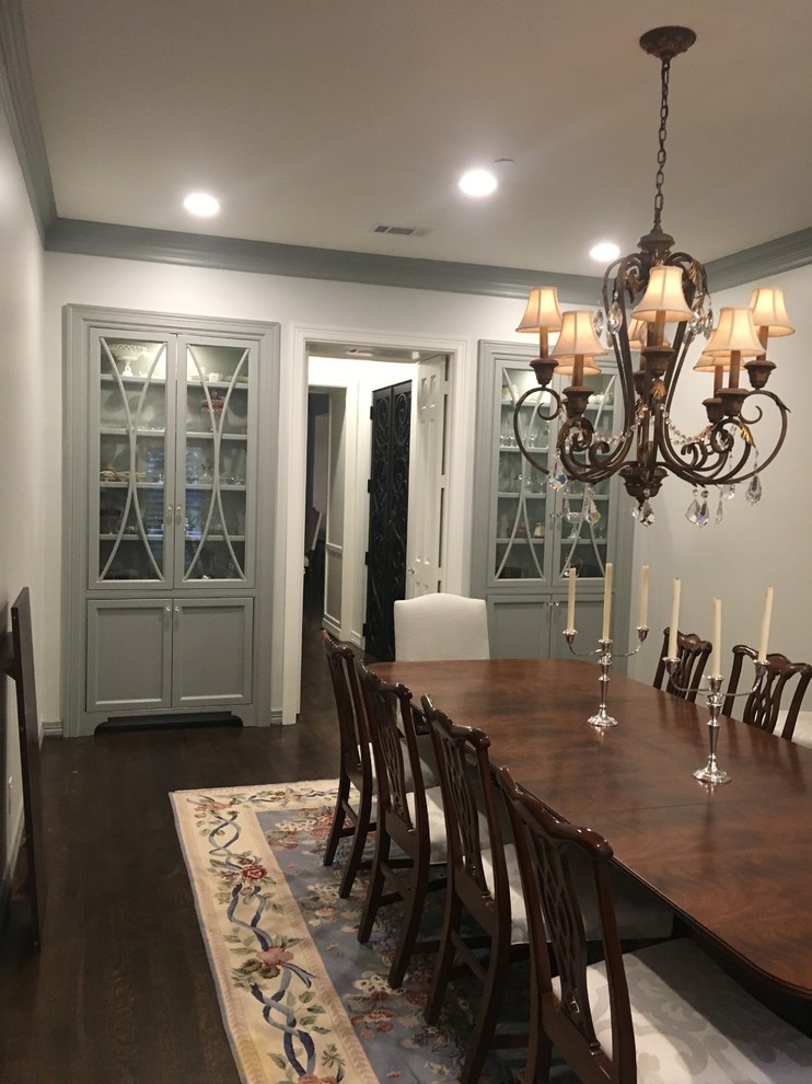 Photo of a mid-sized traditional separate dining room in Houston with white walls, dark hardwood floors, no fireplace and brown floor.