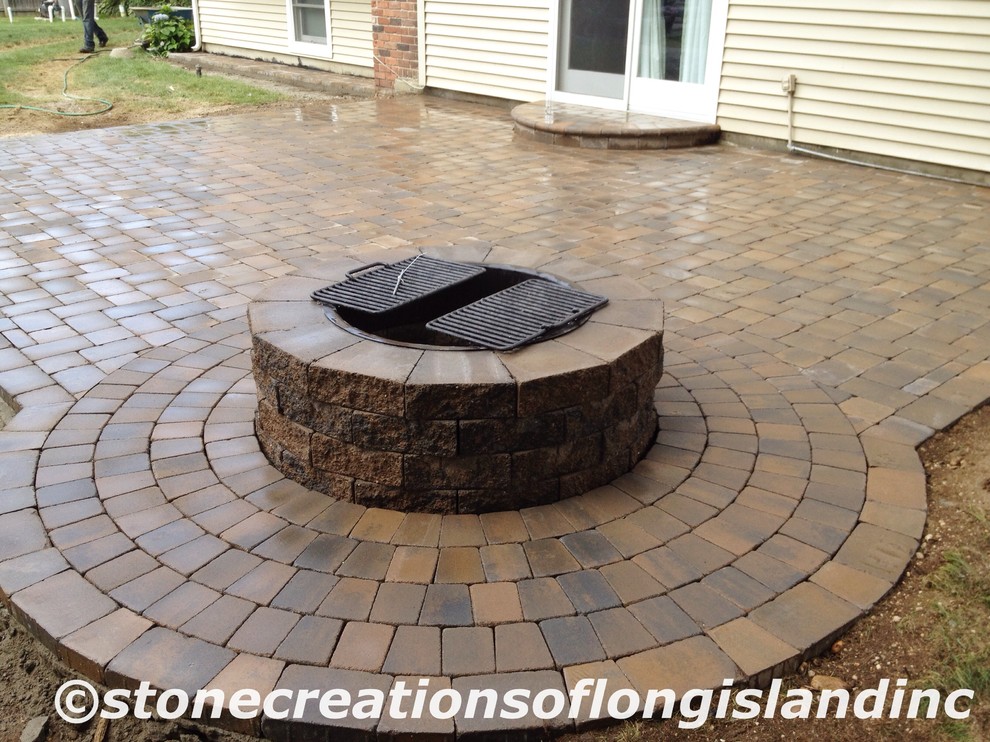 Inspiration for a mid-sized traditional patio in New York with a fire feature and concrete pavers.