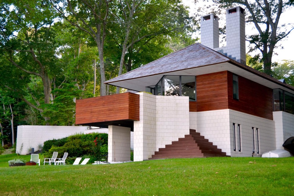 This is an example of a large midcentury two-storey brown exterior in New York with mixed siding and a hip roof.