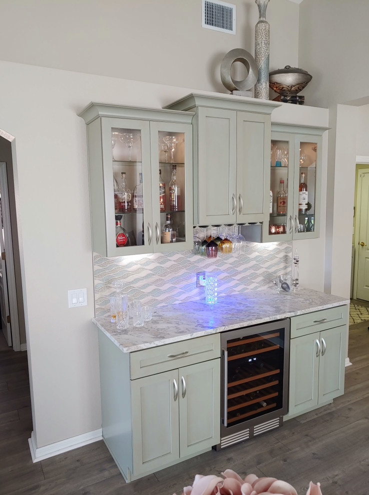 Inspiration for a small transitional galley home bar in Tampa with shaker cabinets, green cabinets, quartzite benchtops, multi-coloured splashback, glass tile splashback and grey benchtop.