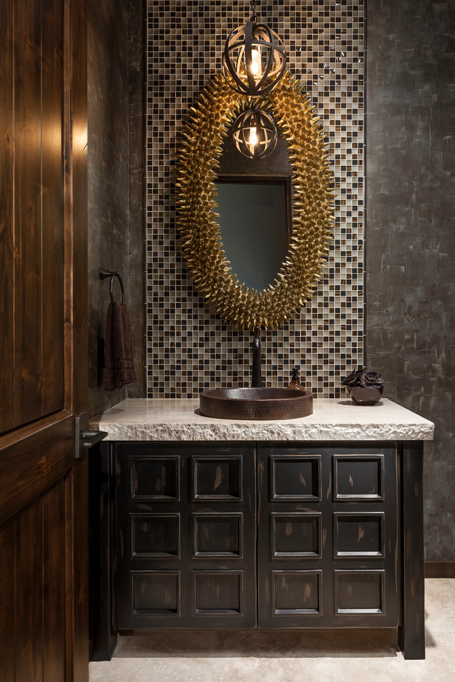 Photo of a large powder room in Phoenix with furniture-like cabinets, dark wood cabinets, multi-coloured tile, mosaic tile, a vessel sink, black walls, travertine floors, concrete benchtops, white floor and grey benchtops.