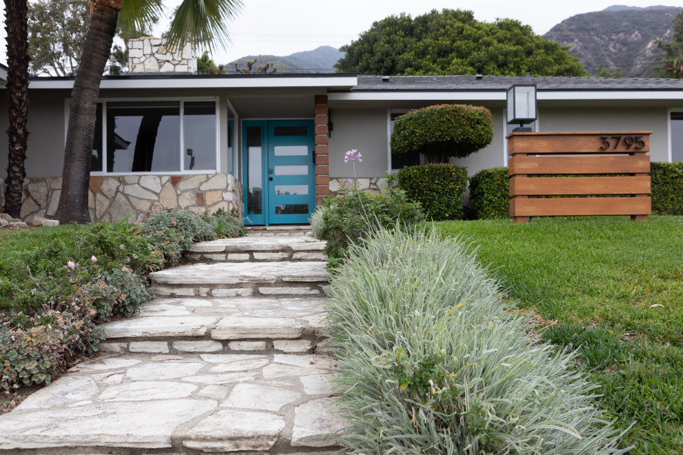 Idée de décoration pour une façade de maison grise vintage en stuc de taille moyenne et de plain-pied avec un toit à quatre pans, un toit en shingle et un toit gris.