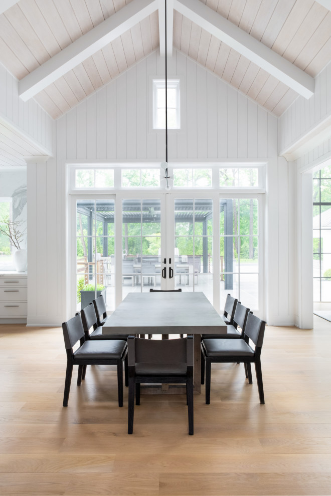 Cette photo montre une grande salle à manger ouverte sur la cuisine chic avec parquet clair, un sol marron et un plafond en lambris de bois.