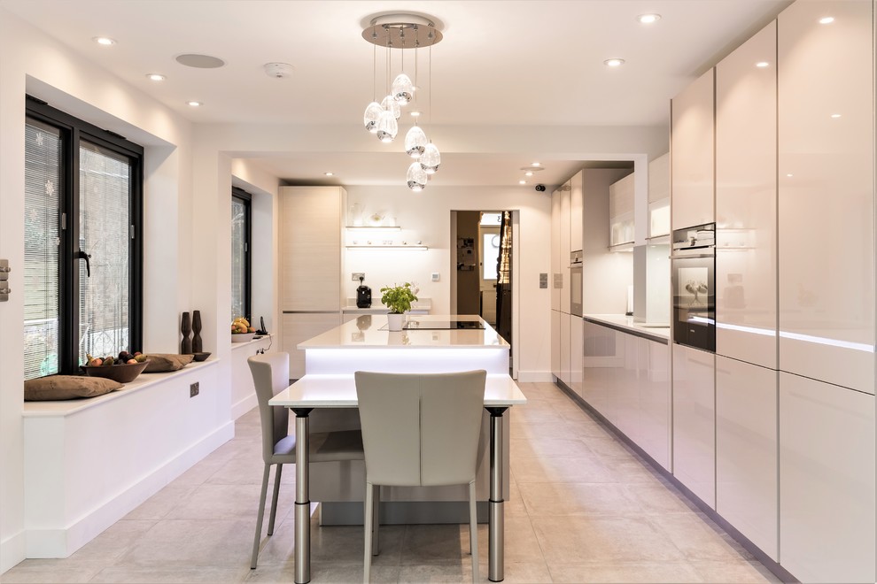 Design ideas for a large modern separate kitchen in London with a single-bowl sink, glass-front cabinets, quartzite benchtops, beige splashback, glass tile splashback, black appliances, porcelain floors and with island.