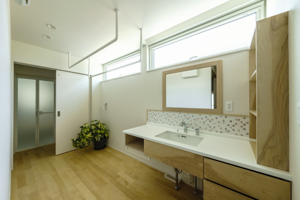 Exemple d'un WC et toilettes moderne de taille moyenne avec un carrelage blanc, mosaïque, un mur blanc, un lavabo intégré, un plan de toilette en surface solide, un sol beige, un plafond en papier peint et du papier peint.