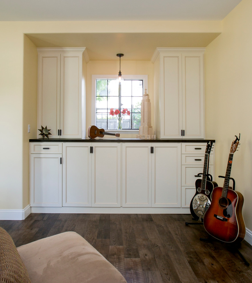 Mid-sized transitional u-shaped utility room in San Francisco with recessed-panel cabinets, white cabinets, quartz benchtops, linoleum floors, a concealed washer and dryer and beige walls.