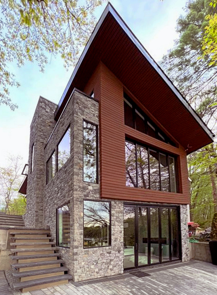 Kleines, Zweistöckiges Modernes Einfamilienhaus mit Mix-Fassade, beiger Fassadenfarbe, Pultdach, Schindeldach, schwarzem Dach und Verschalung in Boston
