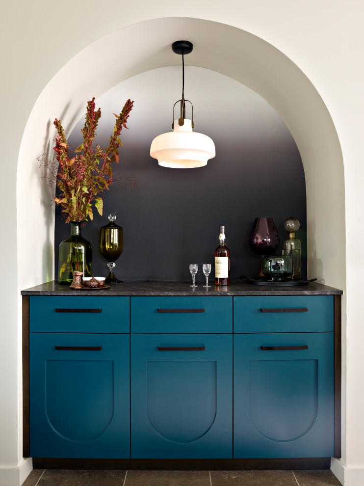 Design ideas for a transitional single-wall home bar in San Francisco with no sink, recessed-panel cabinets, blue cabinets, black splashback, grey floor and grey benchtop.
