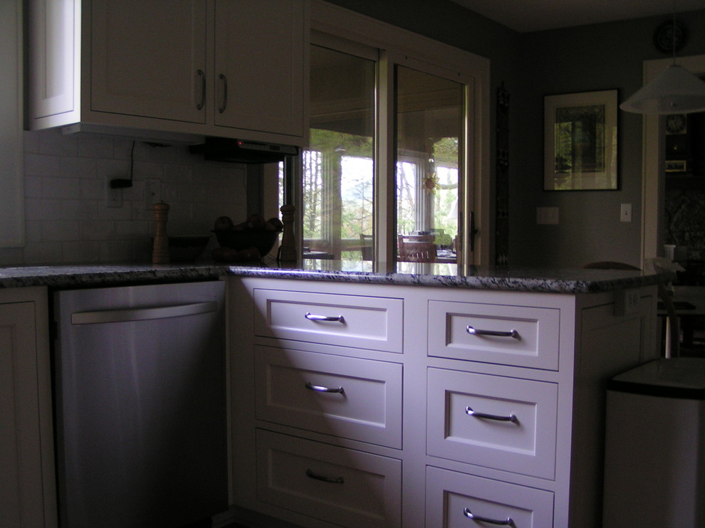 Open concept kitchen - mid-sized transitional u-shaped medium tone wood floor open concept kitchen idea with a double-bowl sink, shaker cabinets, white cabinets, granite countertops, gray backsplash, subway tile backsplash, stainless steel appliances and an island