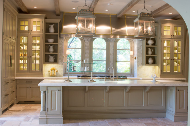 Inspiration for a large traditional l-shaped eat-in kitchen in New York with an undermount sink, recessed-panel cabinets, distressed cabinets, marble benchtops, beige splashback, stone tile splashback, stainless steel appliances, limestone floors and with island.