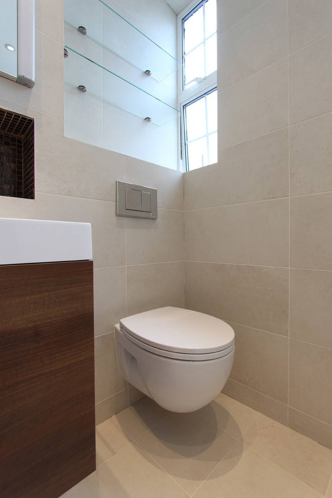 Design ideas for a mid-sized contemporary kids bathroom in London with a drop-in tub, a curbless shower, a one-piece toilet, beige tile, porcelain tile, beige walls, porcelain floors and a console sink.