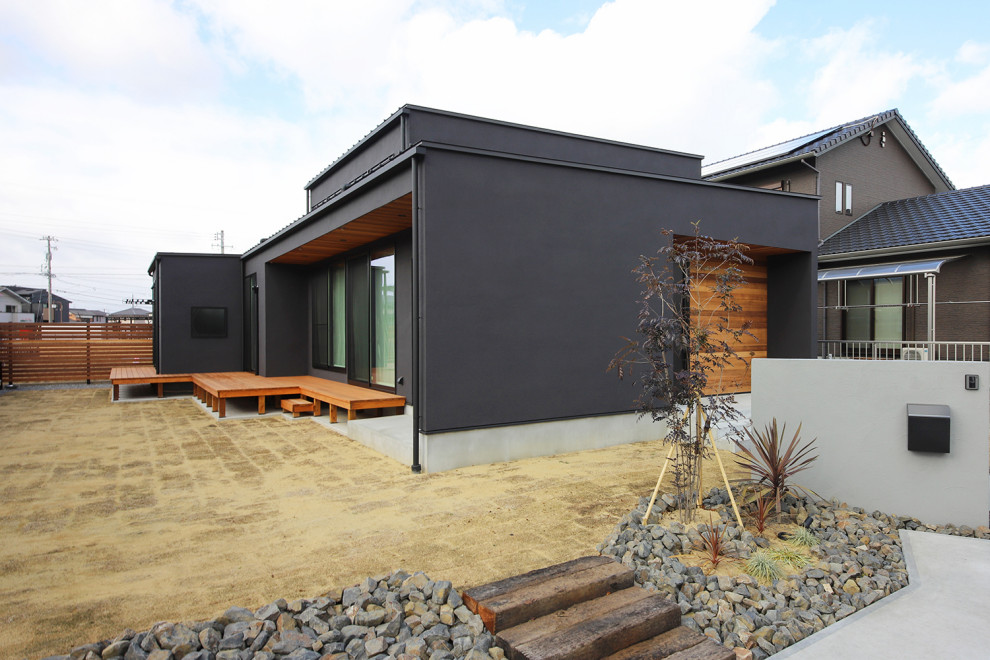 Modelo de fachada de casa negra y negra urbana de una planta con revestimiento de estuco, tejado plano y tejado de metal