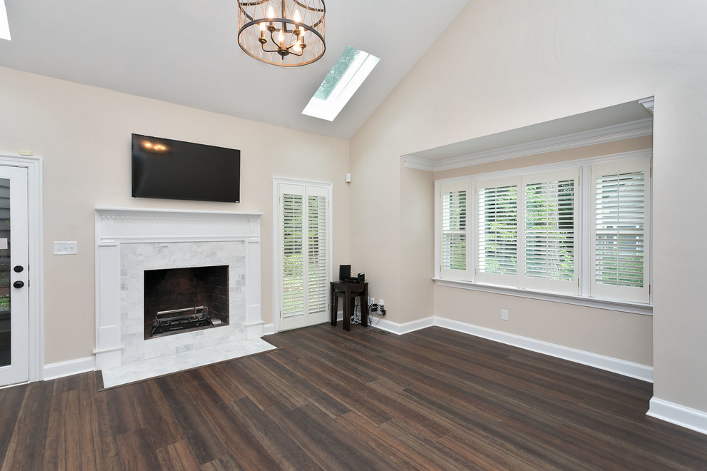 Mid-sized transitional formal enclosed living room in Raleigh with beige walls, dark hardwood floors, a standard fireplace, a stone fireplace surround, a wall-mounted tv and white floor.