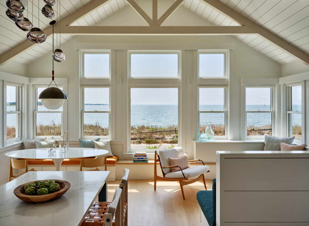 Пример оригинального дизайна: маленькая открытая гостиная комната в морском стиле с белыми стенами, светлым паркетным полом, скрытым телевизором, бежевым полом, балками на потолке и деревянными стенами для на участке и в саду