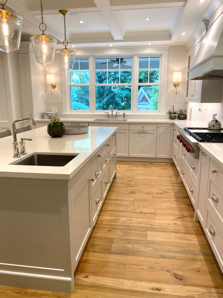 Mid-sized transitional u-shaped medium tone wood floor, brown floor and coffered ceiling open concept kitchen photo in Toronto with an undermount sink, shaker cabinets, quartz countertops, white backsplash, quartz backsplash, paneled appliances, an island and white countertops