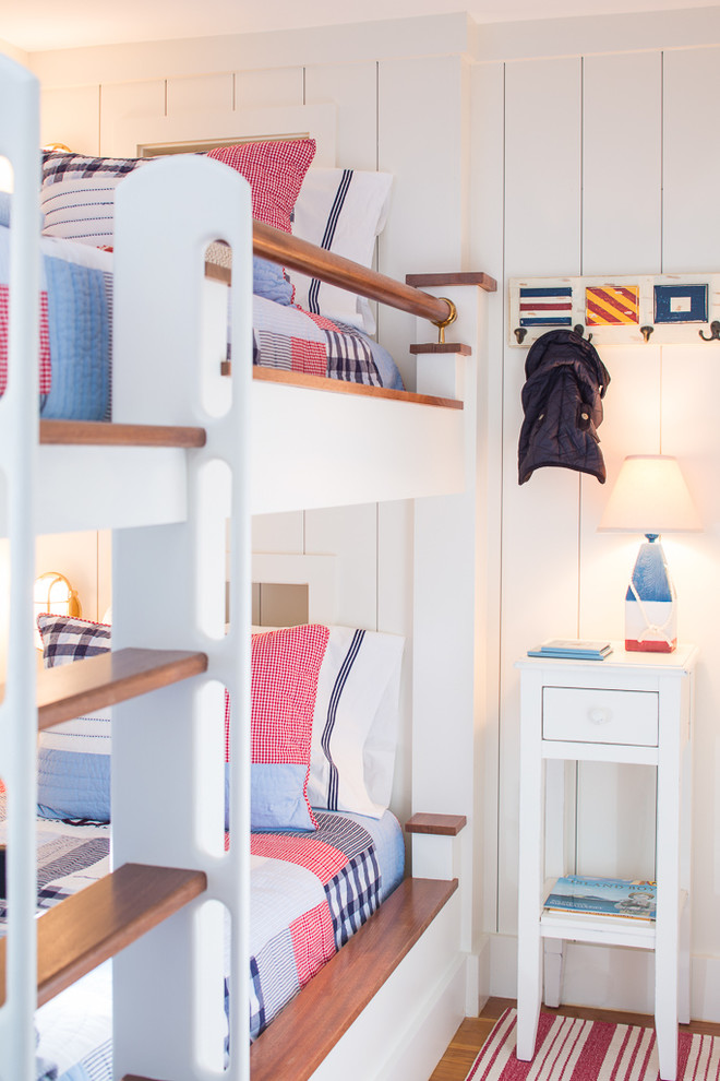 Inspiration for a beach style gender-neutral kids' bedroom in Portland Maine with white walls and medium hardwood floors.