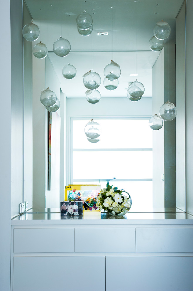 Inspiration for a contemporary walk-in wardrobe in Sydney with white cabinets and carpet.