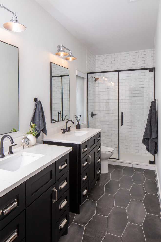 Design ideas for a mid-sized transitional bathroom in Austin with shaker cabinets, black cabinets, an alcove shower, white tile, white walls, an undermount sink, grey floor, white benchtops, a two-piece toilet, subway tile, porcelain floors, engineered quartz benchtops and a hinged shower door.