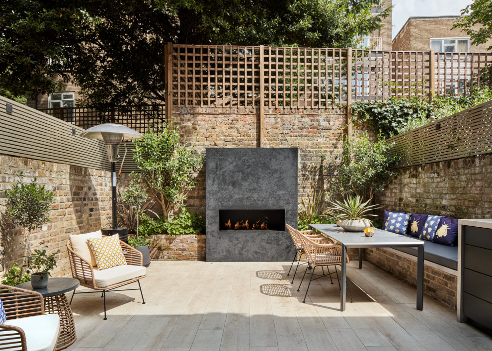 Design ideas for a medium sized classic back patio in London with a fireplace, brick paving and no cover.