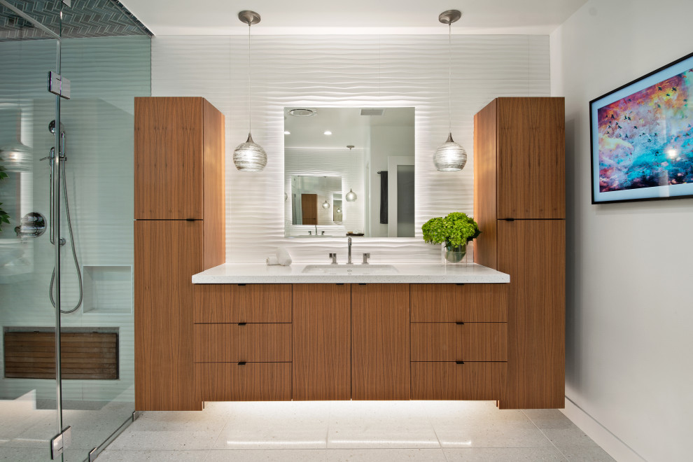 This is an example of an expansive midcentury master wet room bathroom in San Diego with flat-panel cabinets, medium wood cabinets, a freestanding tub, a one-piece toilet, white tile, ceramic tile, white walls, terrazzo floors, an undermount sink, engineered quartz benchtops, beige floor, a hinged shower door, white benchtops, a shower seat, a single vanity and a floating vanity.