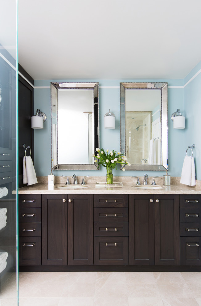 This is an example of a mid-sized traditional bathroom in Toronto with an undermount sink, a corner shower, shaker cabinets, dark wood cabinets, blue walls, travertine floors and beige tile.