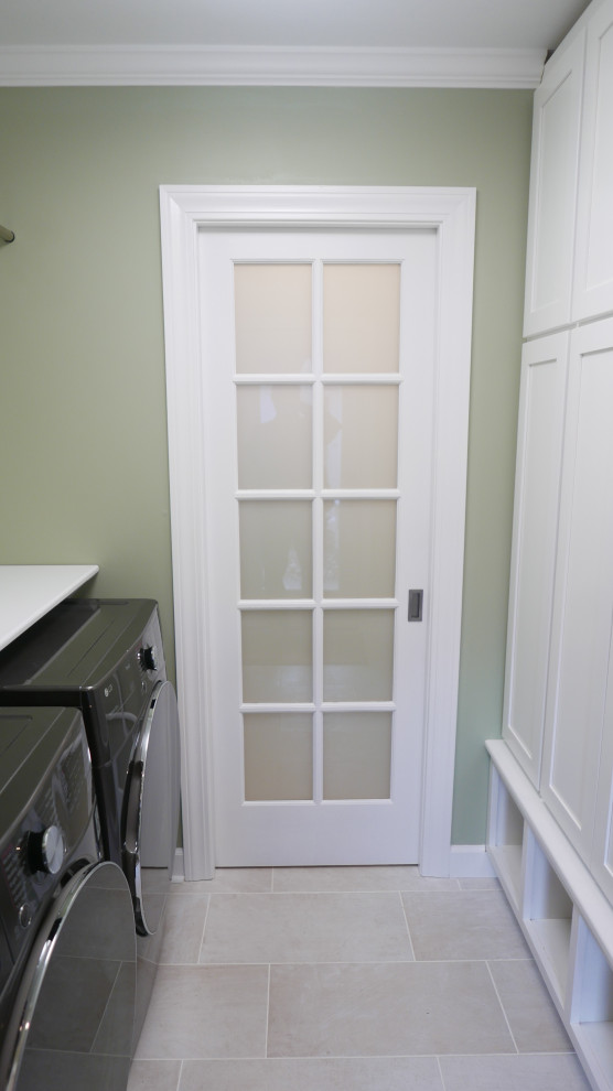 Inspiration for a mid-sized transitional galley utility room in Other with shaker cabinets, white cabinets, green walls, porcelain floors, a side-by-side washer and dryer and beige floor.