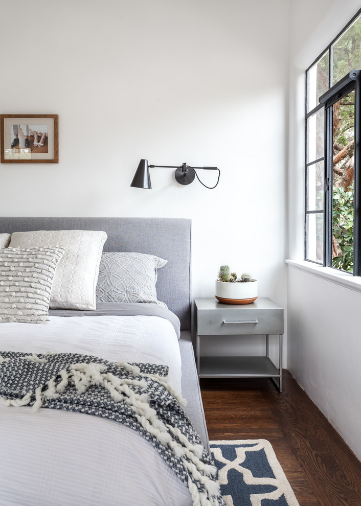 Mediterranean master bedroom in Sacramento with white walls, medium hardwood floors and brown floor.