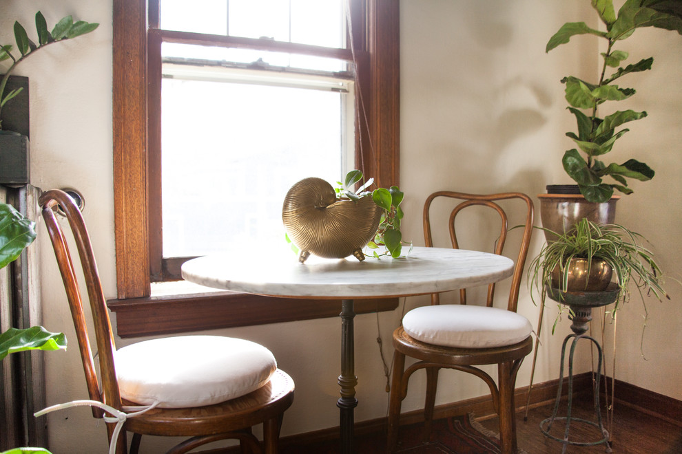 Photo of a small eclectic separate dining room in Seattle with white walls and medium hardwood floors.