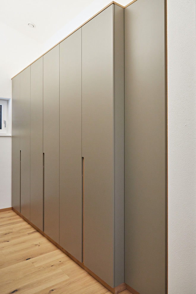 This is an example of a small contemporary gender-neutral dressing room in Munich with flat-panel cabinets.
