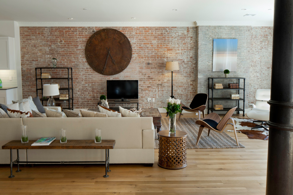 Design ideas for a large industrial loft-style living room in New York with white walls, light hardwood floors and a freestanding tv.